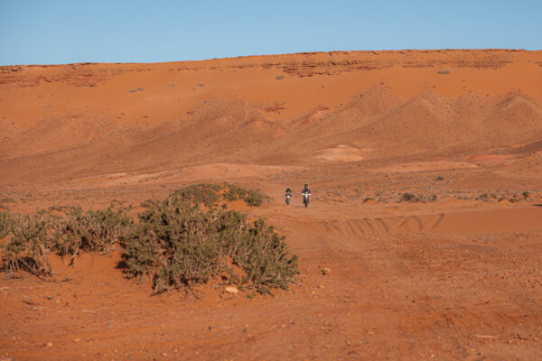 Riders crossing a red desert plain in Morocco