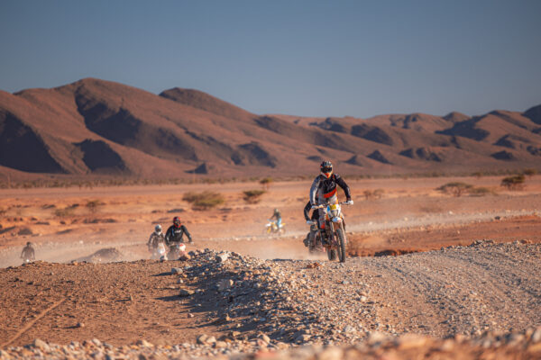 Riders on a desert track below the mountains in Morocco