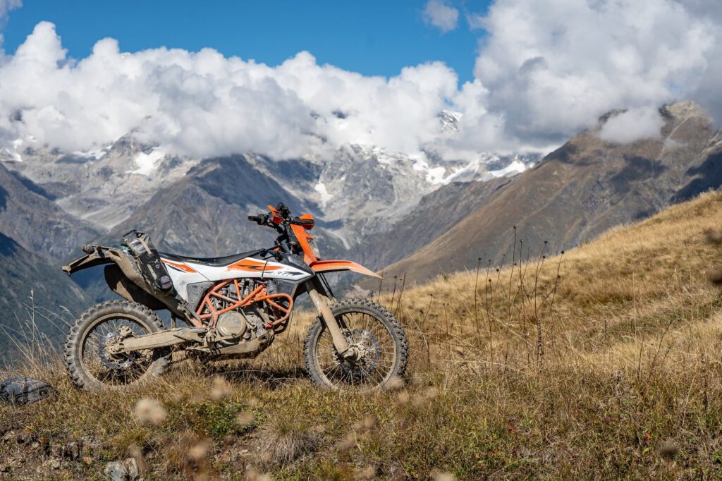 KTM enduro bike below snowy peaks in Georgia